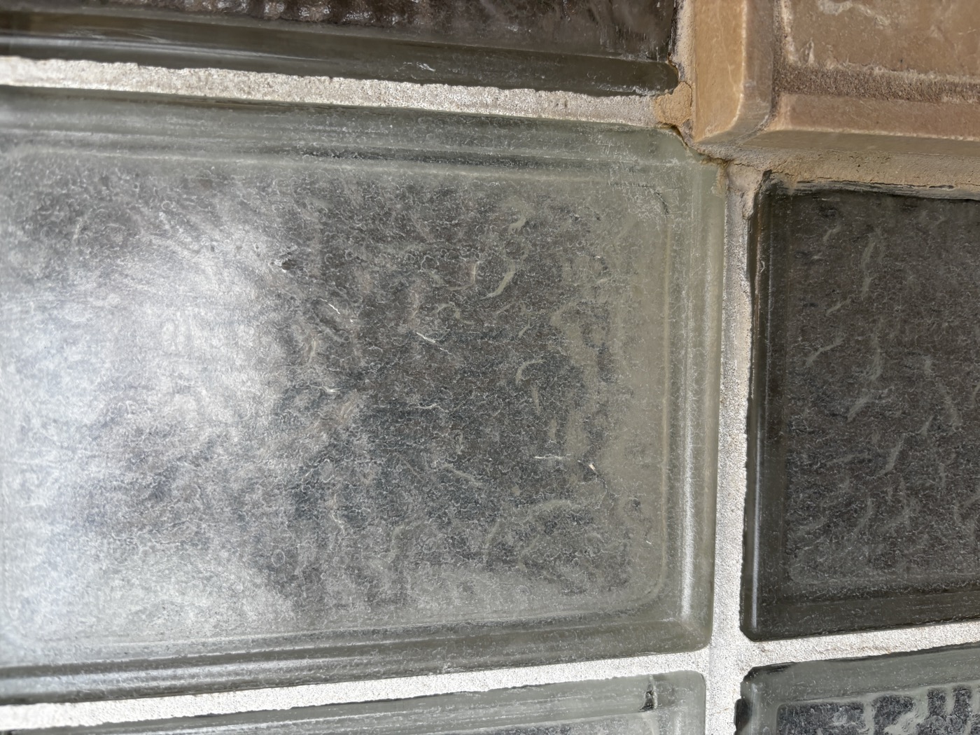 Glass blocks completely coated in hard water mineral deposits