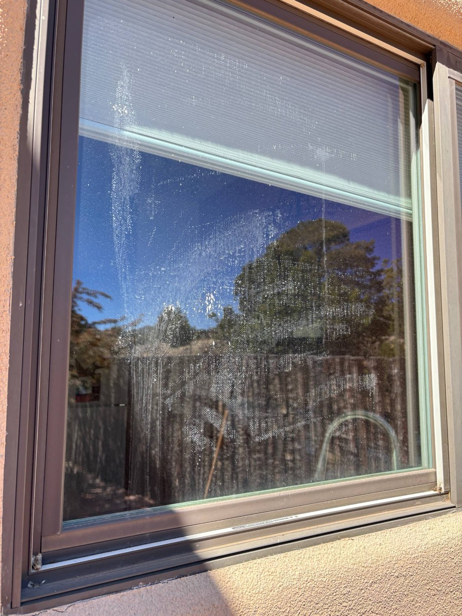 Hard water-stained window before cleaning