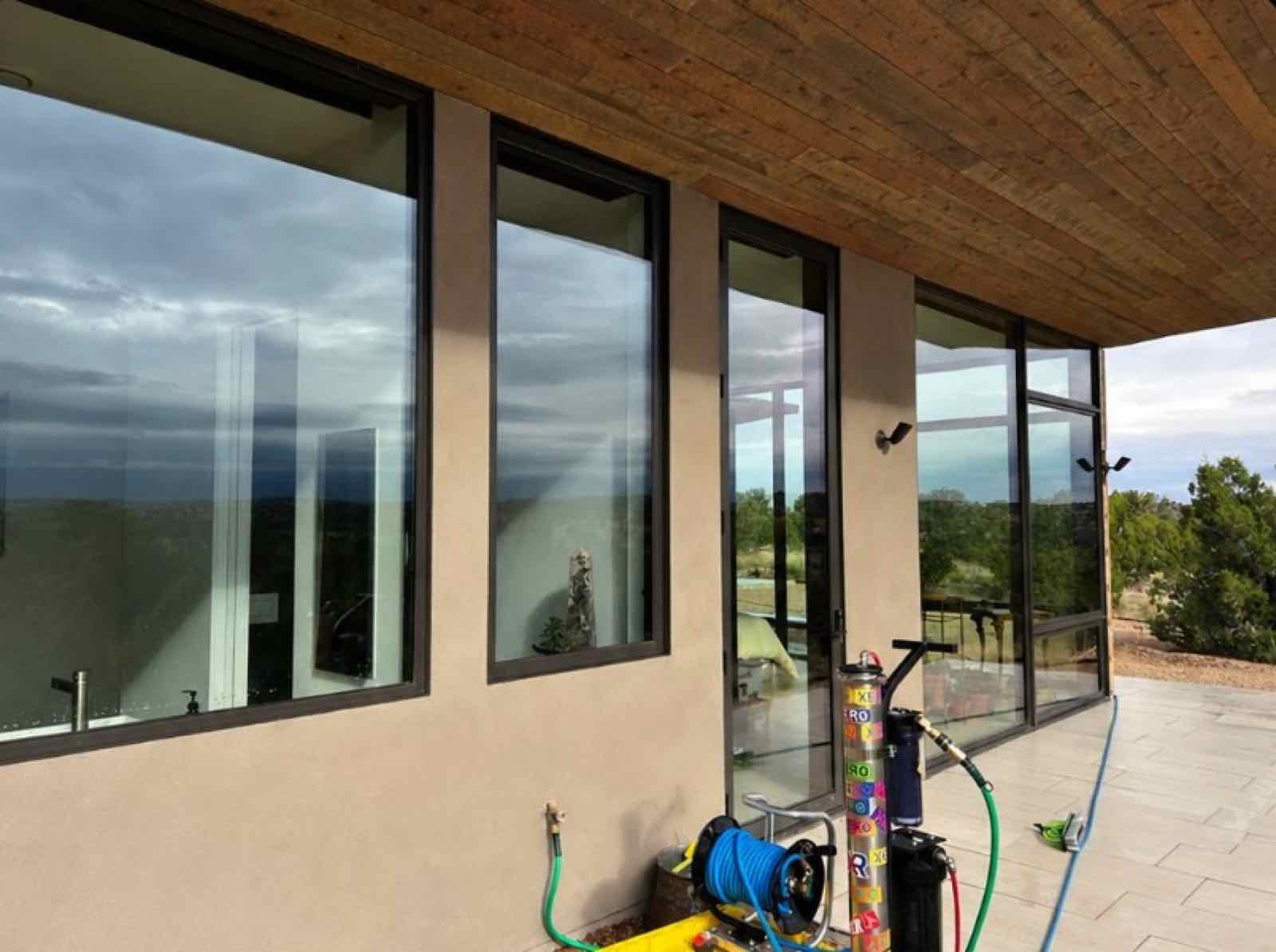 A row of freshly cleaned windows on a Santa Fe home at dusk.