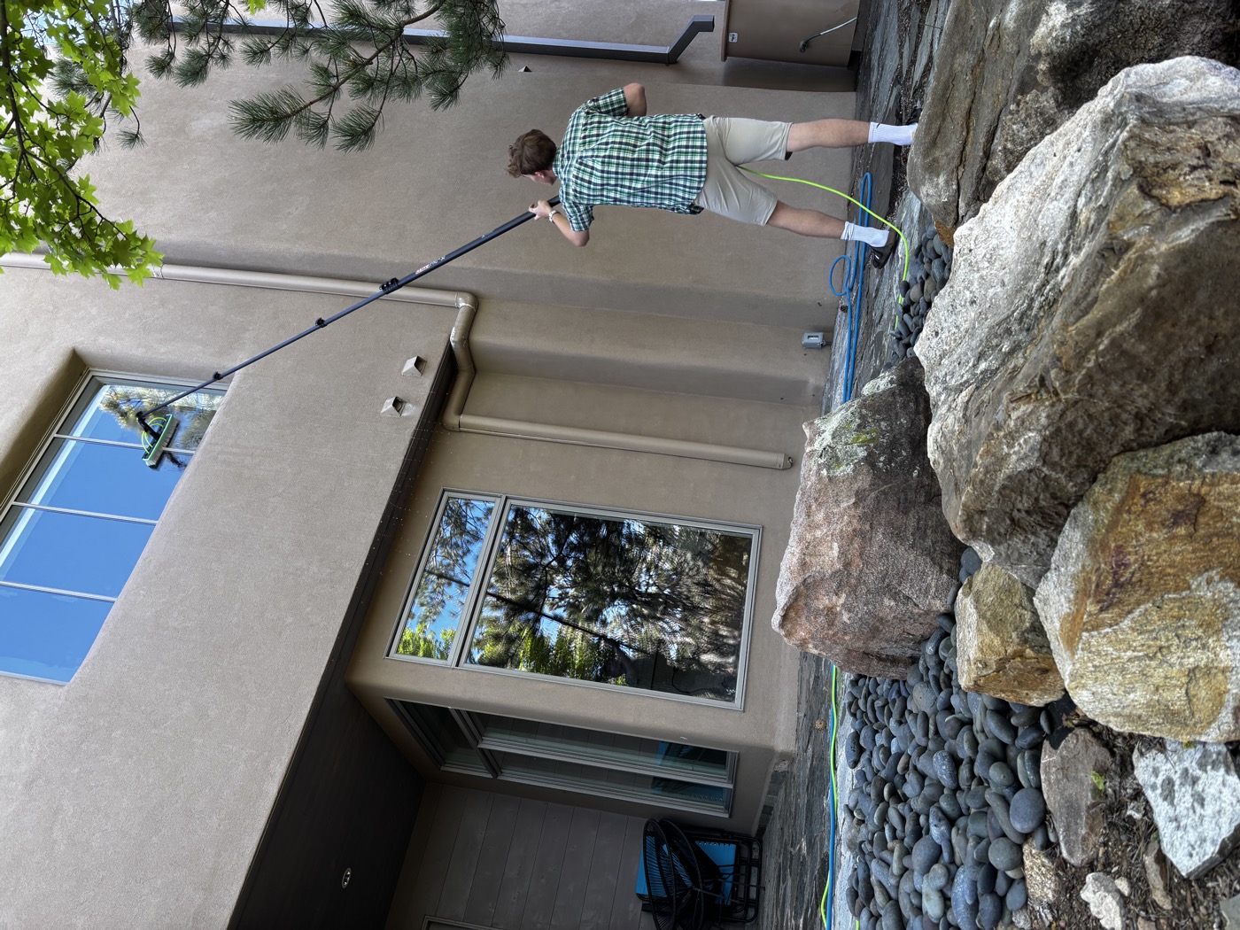 Lake cleaning second-story windows with water-fed pole in Santa Fe